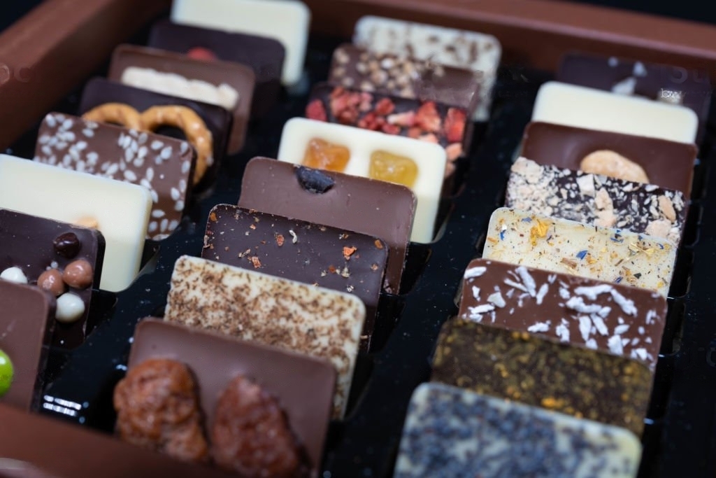 A variety of craft chocolate bars with flavorings and inclusions.